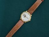 a watch that is laying on a green surface