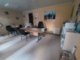 une pièce avec un bureau, des chaises et des tableaux accrochés au mur