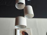 trois lampes suspendues au plafond au-dessus d'un tableau