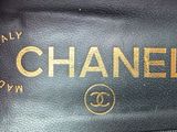chanel logo on a black leather bag with gold lettering
