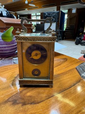 a small clock sitting on a wooden table in a room