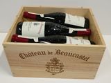 trois bouteilles de vin dans un coffret en bois sur une table
