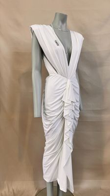 a white dress on a mannequin mannequin stand against a beige backdrop
