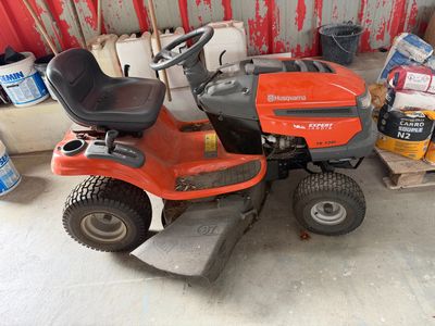 a lawn mower parked in a garage next to a pallet