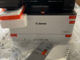 a white printer sitting on top of a plastic box on top of a table