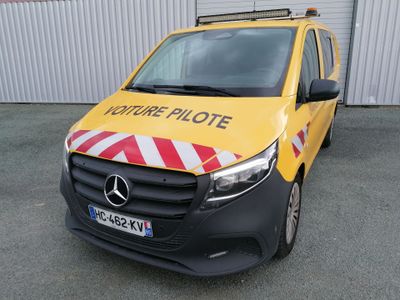 La camionnette est garée devant un immeuble orné d'une bande jaune et rouge.