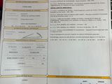 a sheet of paper on a table with a laptop in the background