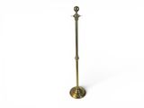 a brass plated floor lamp with a glass shade