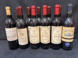 six bouteilles de vin sont alignées sur une table