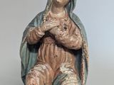 statue of a woman sitting on a chair with her arms crossed