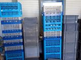 de nombreuses caisses bleues empilées les unes sur les autres dans un garage