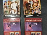 three books on a table with pictures of women and birds on them