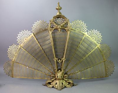 a gold fan with intricate designs on it on a table