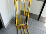 a yellow hand truck that is sitting on the floor