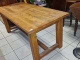 une table et des chaises en bois dans une pièce où se trouve un piano