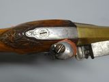 a close up of a rifle with a wooden handle on a table