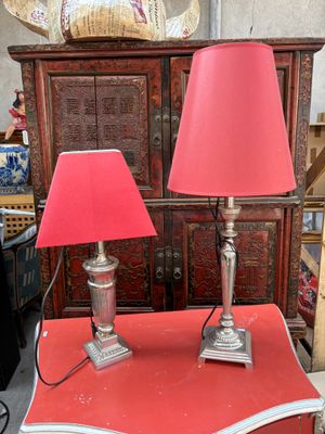 deux lampes rouges posées sur une table rouge dans une pièce