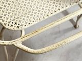 a white chair that has a seat that has holes on it