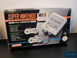 an old nintendo game console sitting on top of a table next to a box