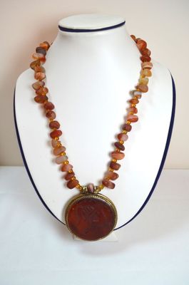 une photo d'un collier sur lequel figure le portrait d'une femme