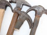 several old hammers are lined up on a white surface
