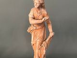 statue of a woman holding a bird on a wooden base