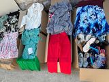 a box full of clothes that is sitting on the ground