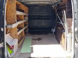 the back of a van with the door open and the back of the van filled with wood planks
