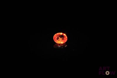 une image représentant une boule de feu dans l'obscurité, avec la lune en arrière-plan