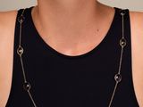 une femme portant un débardeur noir et un collier à chaîne dorée
