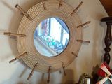 un miroir accroché au mur au-dessus d'une étagère sur laquelle se trouve un petit train miniature