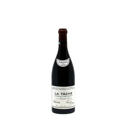 the bottle of red wine is sitting on a white surface
