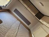 a bed in a small room with a window above it