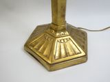 une lampe de table dorée posée sur une table blanche
