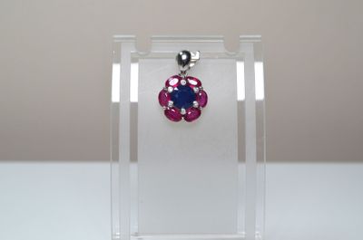 Un pendentif en argent serti au centre d'un saphir facetté r…
