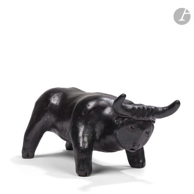 une statue noire représentant un taureau sur fond blanc