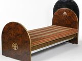 a small bed with a wooden frame and a striped cover