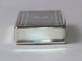 an old silver cigarette case sitting on top of a white table