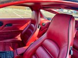 une photo d'une voiture avec des sièges en cuir rouge dans un parking