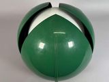 une boule verte et blanche posée sur une surface blanche