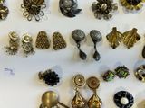 many different types of jewelry displayed on a white surface