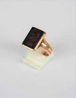 Gros plan sur une bague en or ornée d'une pierre noire