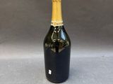 a bottle of champagne on a table with a gray background