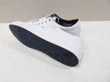 white sneakers with black soles on a white surface