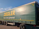un semi-remorque vert garé sur le bord de la route