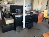 a room with a desk, chairs, and a computer monitor in it