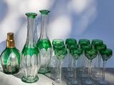 bottles and glasses are lined up on a table in front of a blue wall