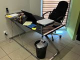 a glass desk with a laptop on it in a room