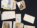 many old postcards and envelopes on a table