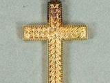 une image représentant un pendentif en forme de croix en or sur fond blanc